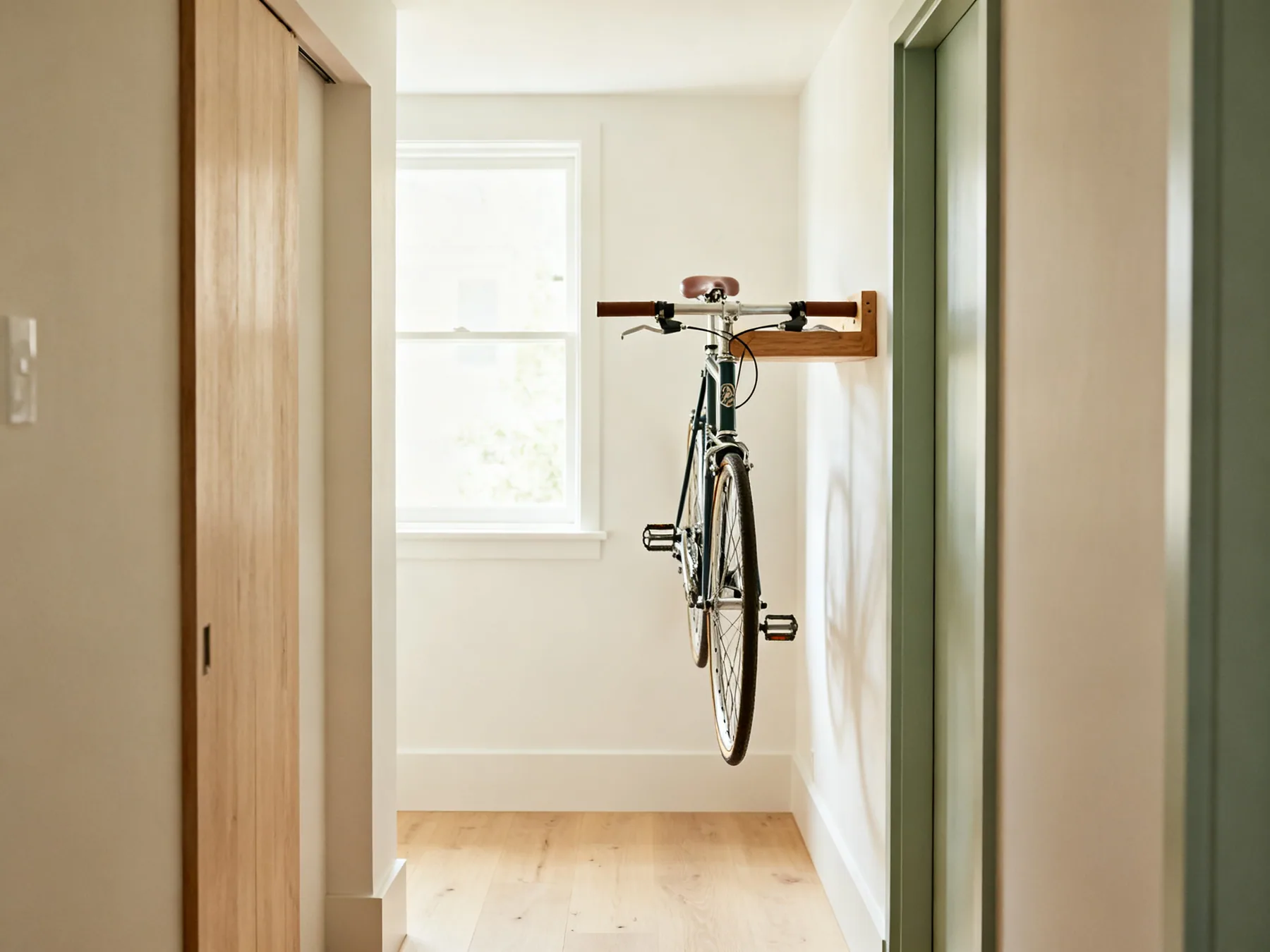 Horizontal mounting where height is short A bicycle on a horizontal wall mount in a narrow hallway with the frame parallel to the wall and the top tube resting in a timber cradle, floor clear beneath